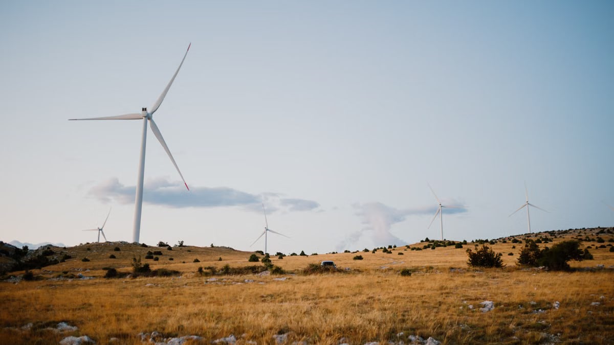 Wind turbines on a serene field in Mostar, showcasing clean energy.